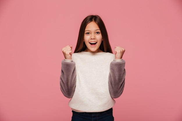 Smiling girl making winner gesture while looking