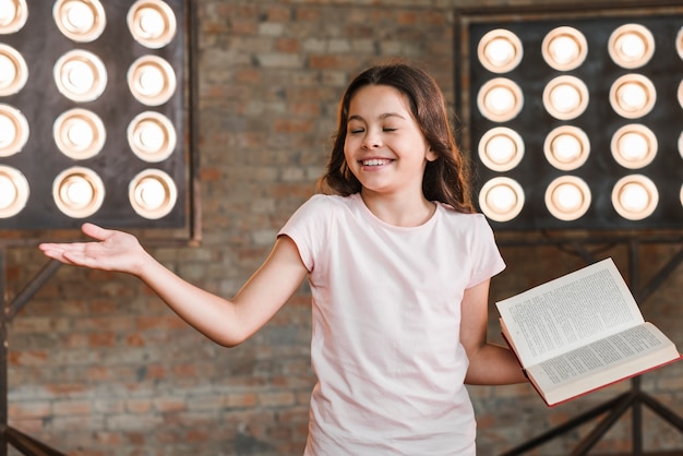 Free photo smiling girl performing against stage light