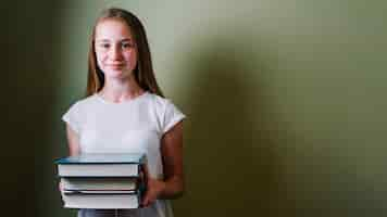 Free photo smiling girl standing with books