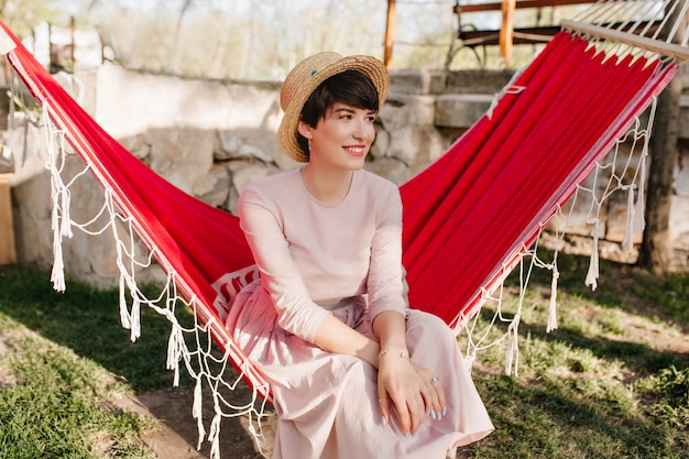 Free photo smiling girl with elegant manicure wearing long retro dress resting outdoor in sunny day