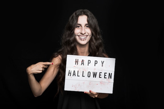 Smiling girl with spooky makeup and signboard