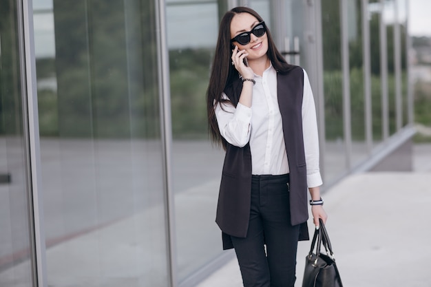 Smiling girl with sunglasses talking on her phone