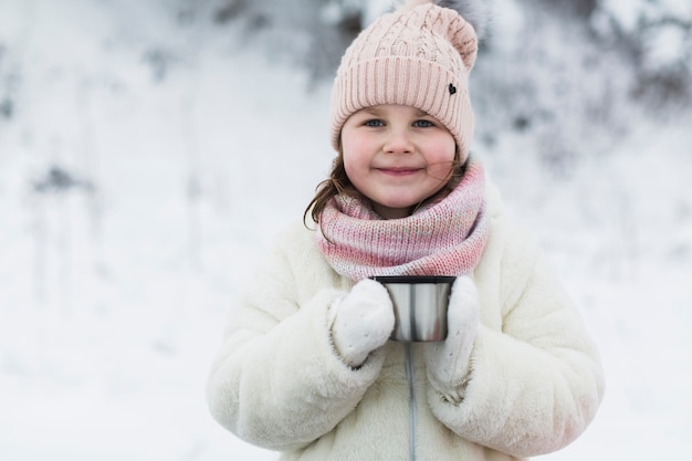 Free photo smiling girl with thermos cap