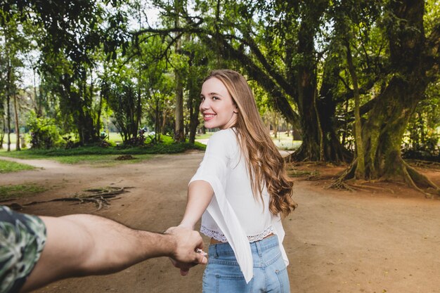 Smiling girlfriend pulling boyfriend