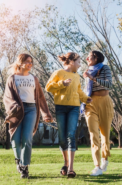 Free photo smiling girls walking on green grass in park