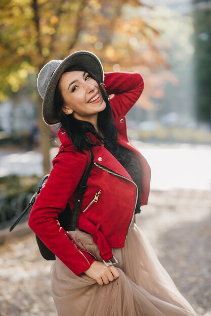 Smiling gorgeous lady with black hair enjoying autumn day