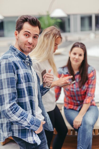 Smiling guy with his friends on background