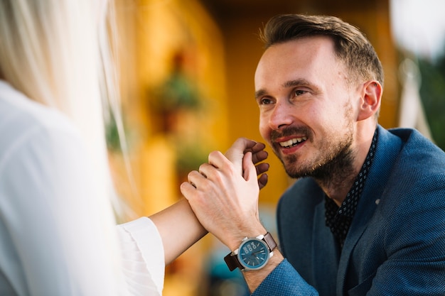 Free photo smiling handsome man holding her girlfriend's hand