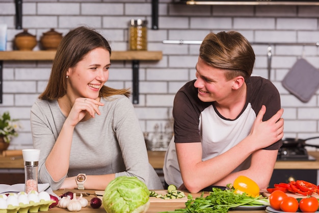 Free photo smiling happy couple cooking together in kitchen