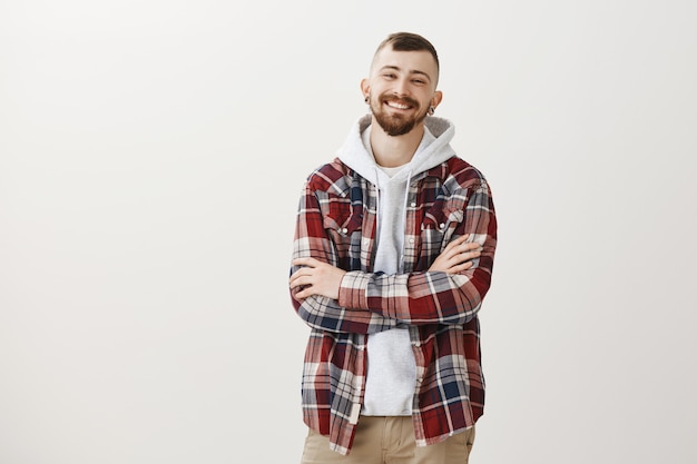 Smiling happy hipster guy cross arms on chest confident and laughing