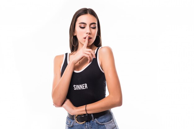 Smiling happy woman with braces hold her finger in front of her mouth