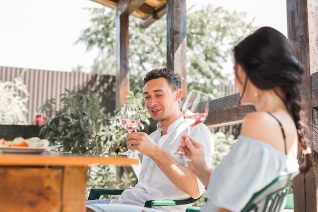 Free Photo smiling happy young couple enjoying the wine in the garden