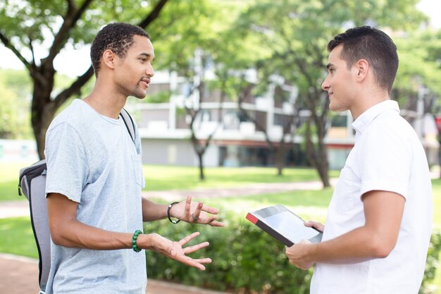 Smiling high school students communicating outdoor