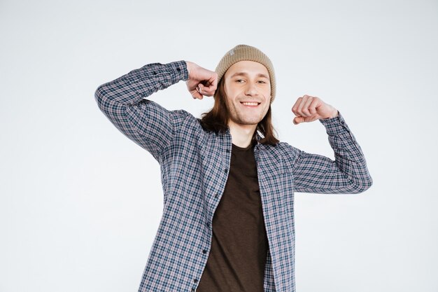 Smiling Hipster showing his biceps