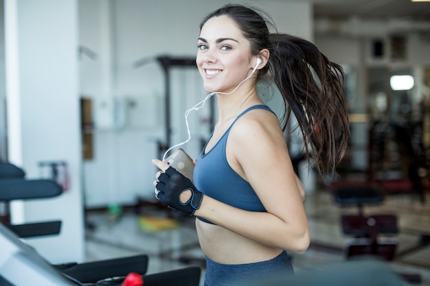 Smiling jogging woman listening to music