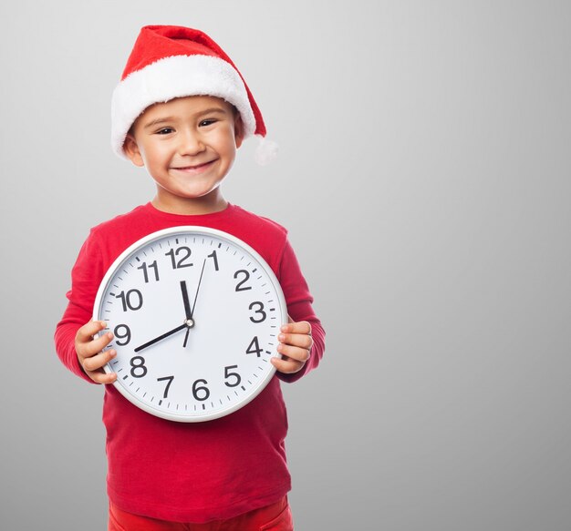 Smiling kid holding a clock