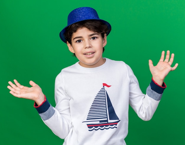 Free photo smiling little boy wearing blue party hat spreading hands