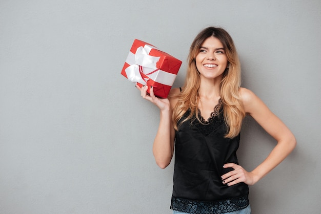 Free Photo smiling lovely woman holding present box and looking away