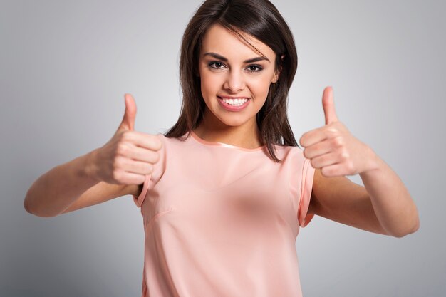 Smiling lovely woman showing thumbs up