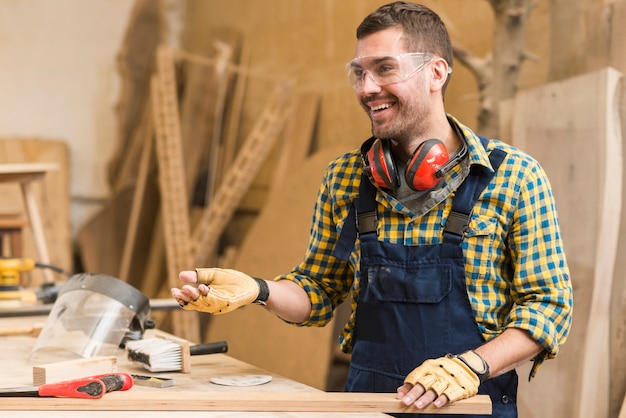 Free photo smiling male carpenter at work in the workshop