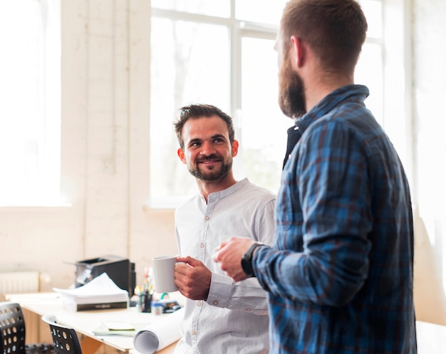 Free photo smiling male coworker talking during break