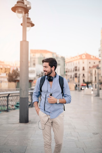 Smiling male tourist walking on pavement