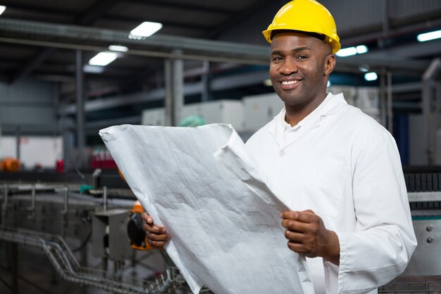 Free Photo smiling male worker reading instructions at juice factory