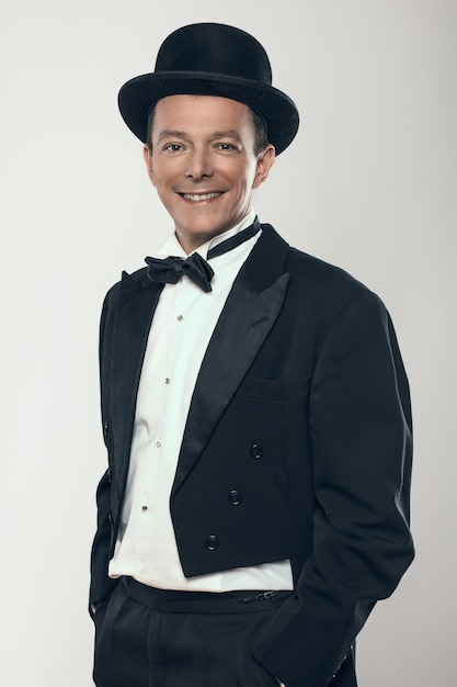 Free photo smiling man in black suit and cylinder hat.