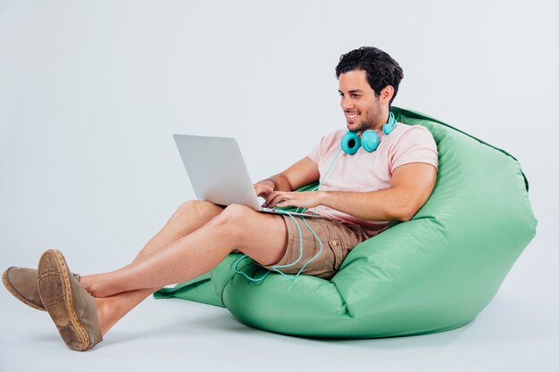 Smiling man on couch holding laptop