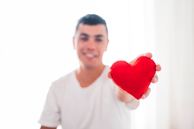 Free photo smiling man holding decorative heart