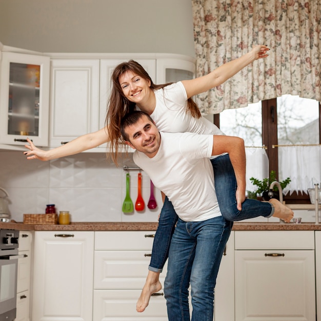 Smiling man holding woman on his back