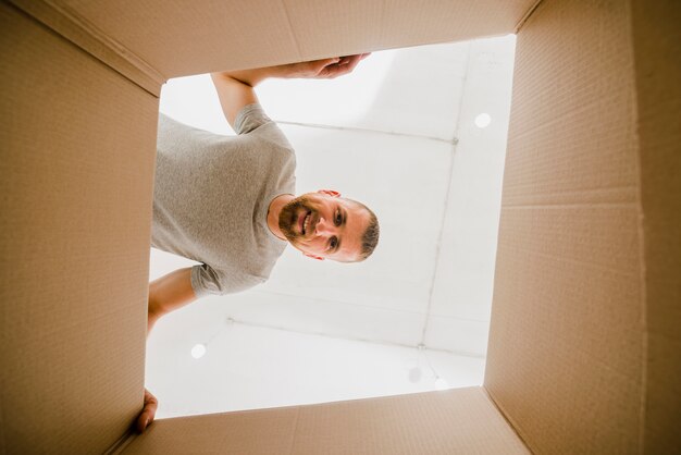 Smiling man looking inside box