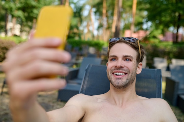 A smiling man making selfie and looking excited