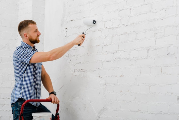 Smiling man painting wall