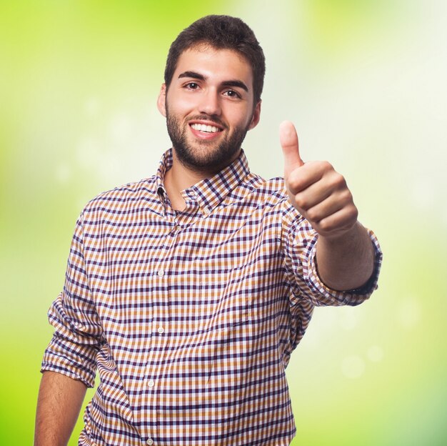 Smiling man showing big finger gesture. 