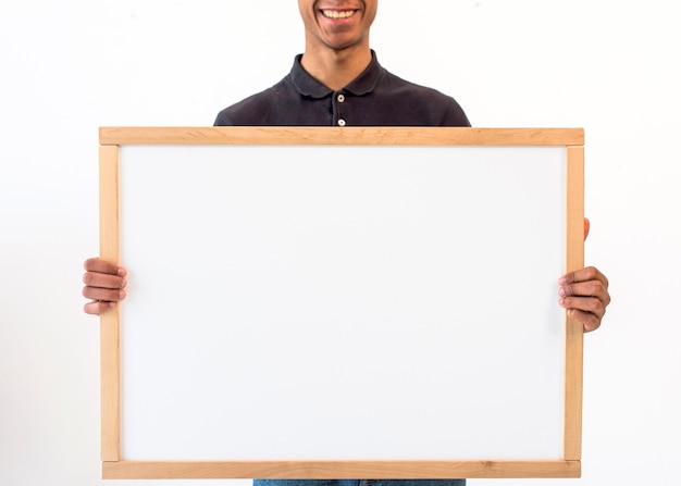 Free photo smiling man showing blank empty white board