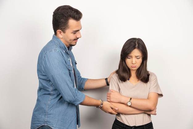 Smiling man and upset woman on white.