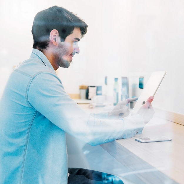 Free photo smiling man using tablet