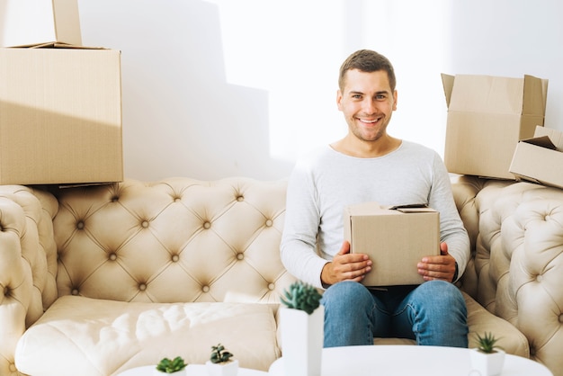 Free photo smiling man with cardboard box