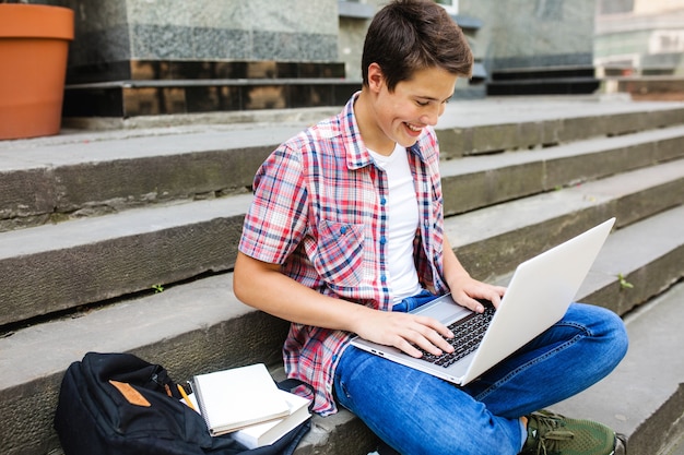 Smiling man with laptop studying