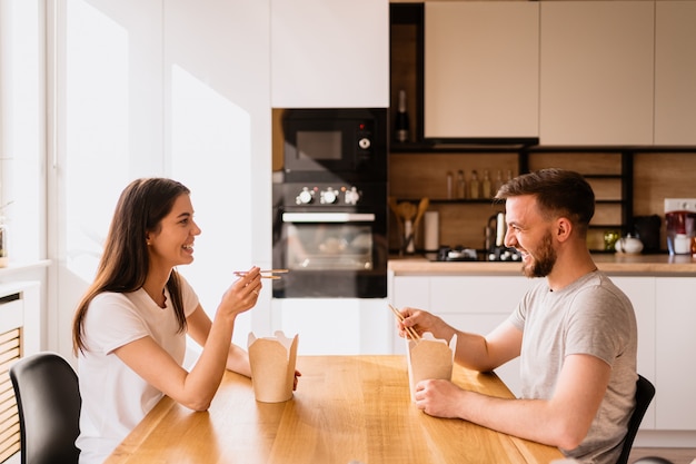 Smiling man and woman having lunch together at home