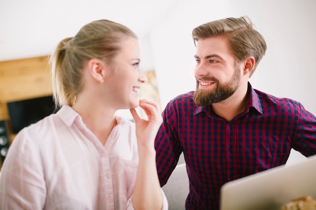 Smiling man and woman at laptop