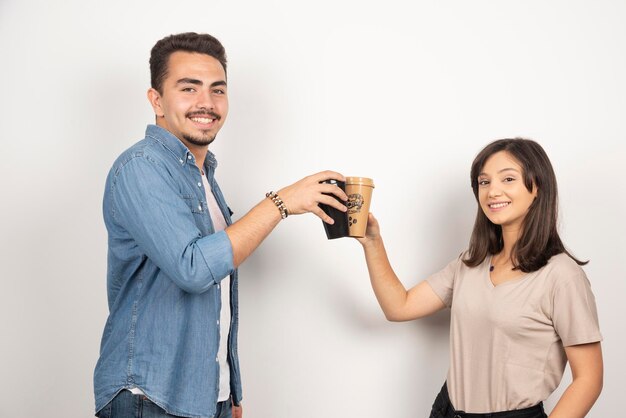 Smiling man and woman with cups of coffee. 