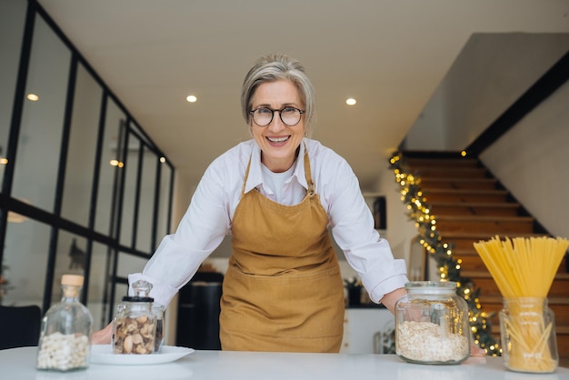 Smiling middle aged mature grey haired woman looking at camera