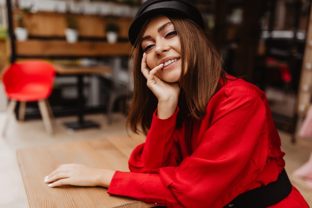 Smiling model with pretty face looks attractively into lens. Portrait of Parisian-style European girl with short brown hair