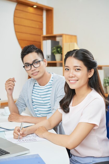 Smiling modern woman with man in office