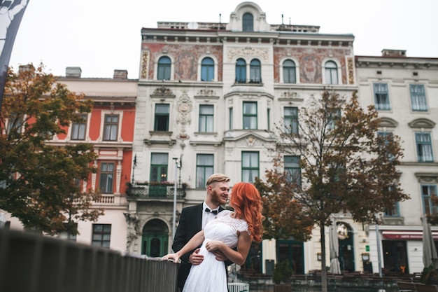 Smiling newlyweds posing next to a railing