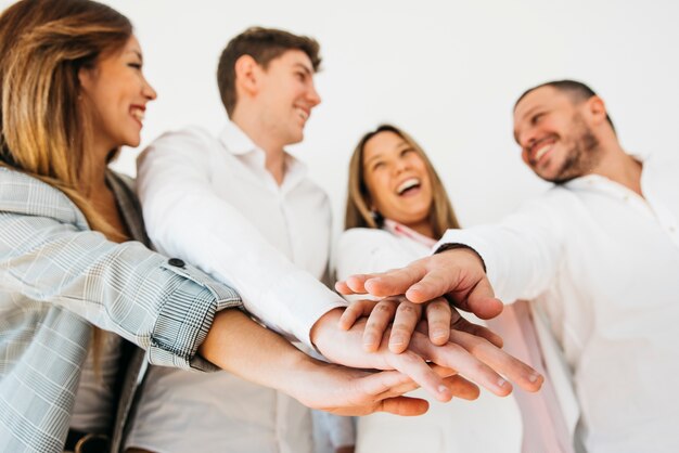 Smiling office coworkers putting hands together