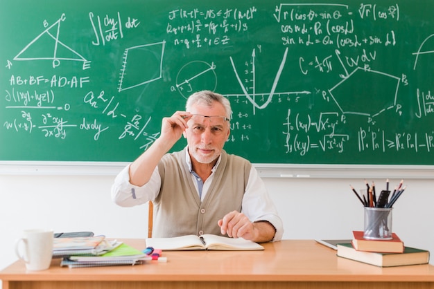 Free Photo smiling old professor of maths in classroom