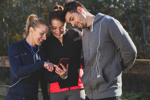 Smiling people looking at a photo on the mobile